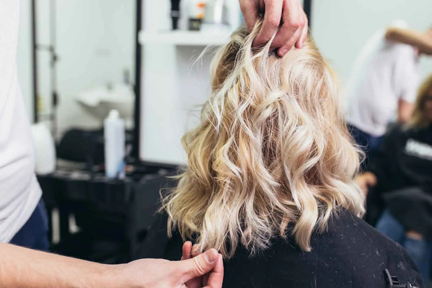 Salon professional adjusting client's hairstyle